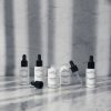 Vegan skin care from N.C.P Essentials. The boost line of Skin care on marbel table. Age Care Serum and Skin Balance Serum is open and showing the pipette.Age Care Serum, Hydro Active Serum, Night Boost Serum, Skin Balance Serum & Skin Defence Serum